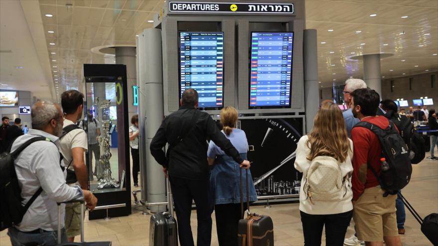 Pasajeros observan un panel de salidas en el aeropuerto Ben Gurión, cerca de Tel Aviv, mientras los vuelos se cancelan y retrasan debido a un ataque sorpresa masivo de HAMAS, 7 de octubre de 2023. (Foto: AFP)