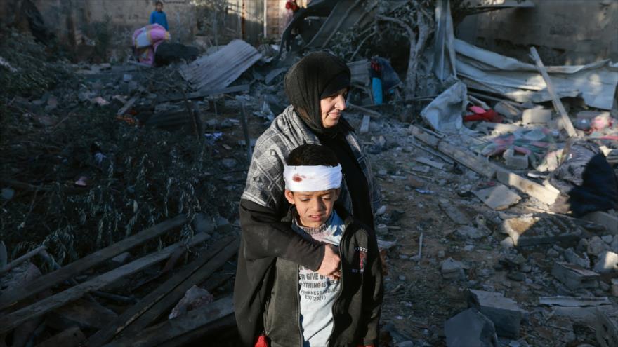 Una mujer y un niño palestinos revisan los escombros de un edificio tras el bombardeo israelí en Rafah. (Foto: AFP)