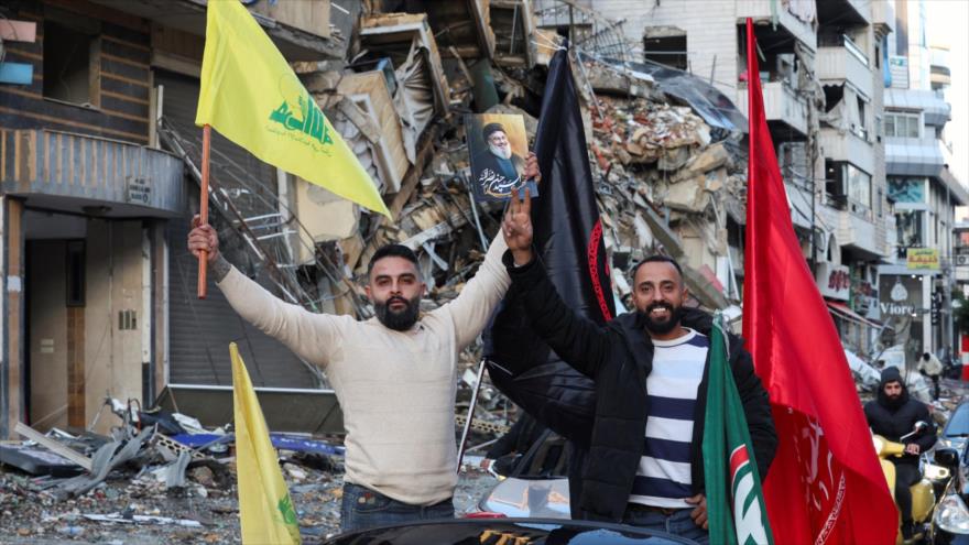 Libaneses con bandera de Hezbolá y foto del mártir Seyed Hasan Nasralá, celebran victoria ante Israel, Beirut, 27 de noviembre de 2024. (Foto: Reuters)