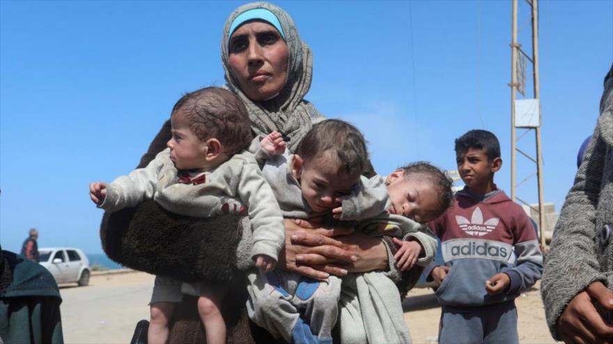  La mujer palestina Nozha Awad huye del hospital Al-Shifa tras una redada israelí con sus trillizos y se dirige hacia el sur de Gaza, 21 de marzo de 2024. (Foto: REUTERS)