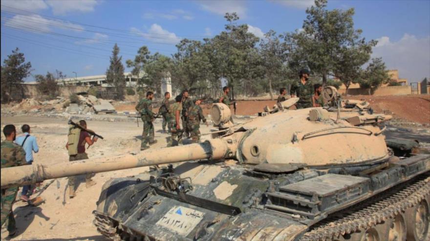 Las Fuerzas Armadas de Siria junto a un tanque en un complejo militar, después de que recuperaron áreas en el suroeste de Alepo. (Foto: Reuters)