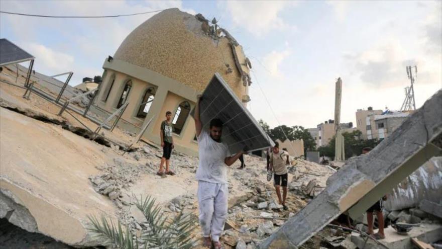 Un hombre retira un panel solar de una mezquita destruida en un ataque aéreo israelí en Jan Yunis, en Gaza. (Foto: AP)
