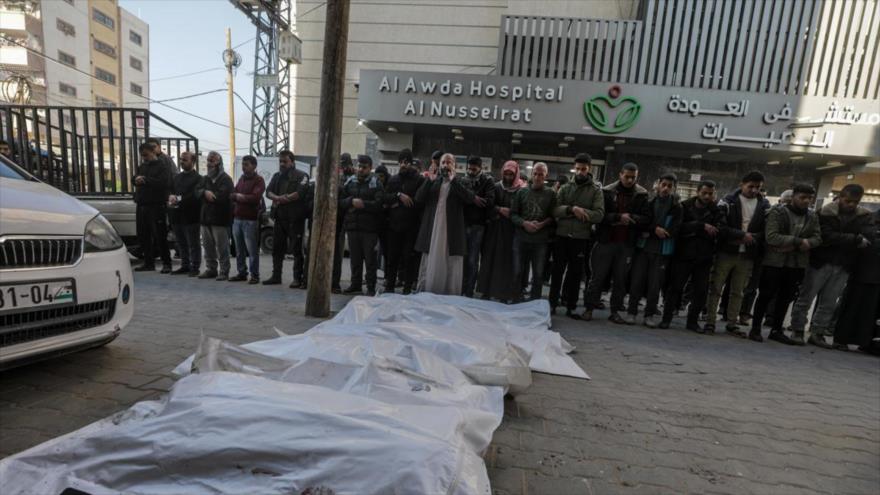 Palestinos rezan afuera del Hospital Al Awda sobre los cuerpos de una familia asesinada en un ataque israelí en Al-Nuseirat, 1 de diciembre de 2024.