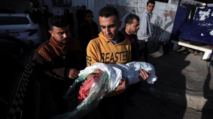 Un hombre palestino lleva el cuerpo de un niño muerto en ataques israelíes en Rafah, sur de Gaza, 7 de diciembre de 2023. (Foto: reuters)