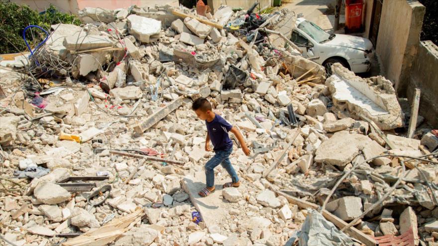 Un niño palestino camina entre las casas destruidas por ataques israelíes en el campamento de refugiados de Yenín, en Cisjordania, 4 de septiembre de 2024.