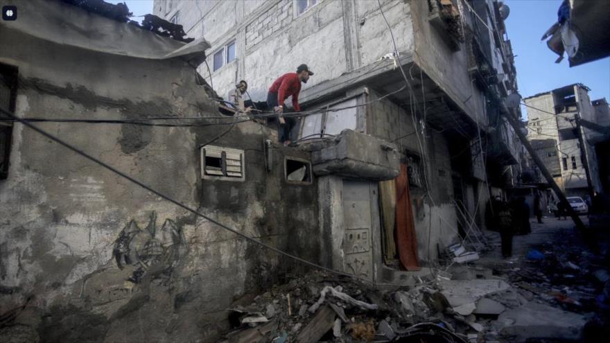 Un hombre palestino inspecciona daños en tejado de una casa en campo de refugiados de Nuseirat, centro de Gaza, 16 de diciembre de 2024.