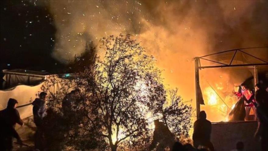 Las carpas de los palestinos en llamas de fuego tras ataque israelí en la zona humanitaria de Al-Mawasi, sur de Gaza, 23 de diciembre de 2024.