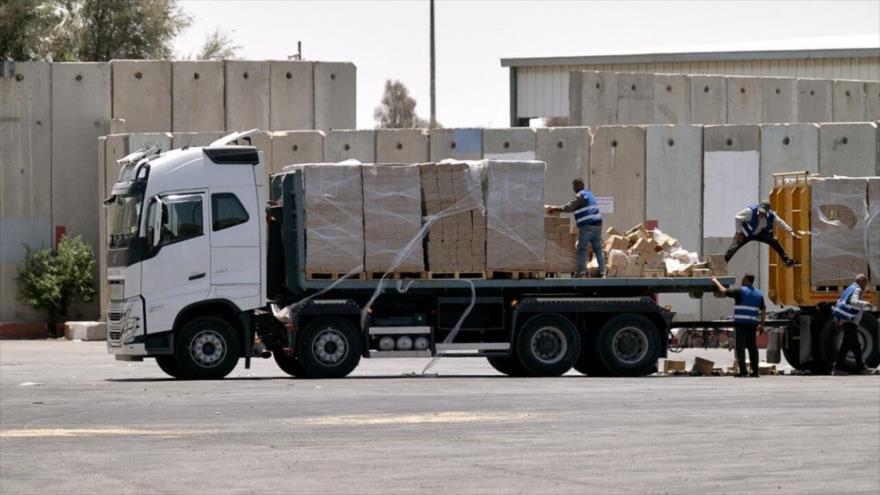 Un camión que transporta ayuda humanitaria para la Franja de Gaza se carga en el cruce fronterizo de Kerem Shalom, sur de Gaza, 17 de junio de 2024. (Foto: AFP)