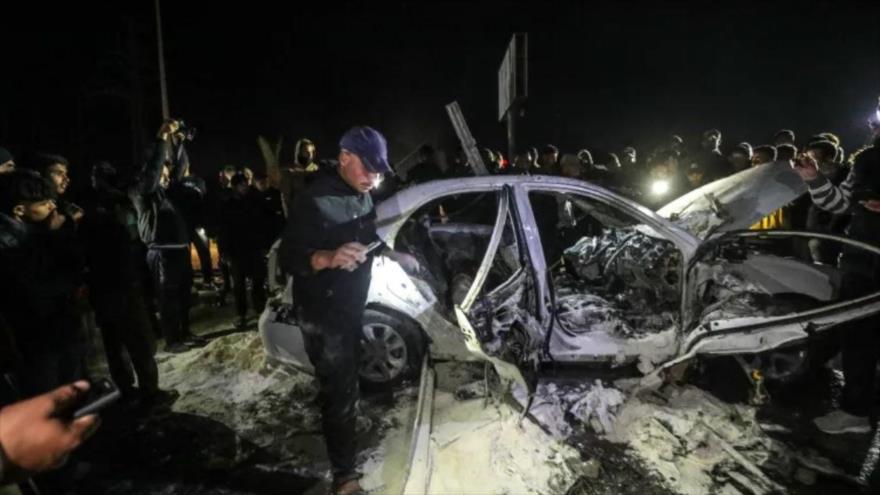 Palestinos inspeccionan un automóvil dañado tras un ataque aéreo israelí en Deir el-Balah, en el centro de la Franja de Gaza, 23 de diciembre de 2024.
