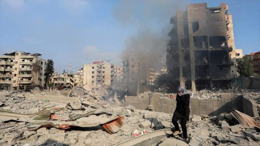 Una mujer camina sobre los escombros de un sitio dañado por ataques israelíes en Choueifat, al sudeste de Beirut, 6 de octubre de 2024.