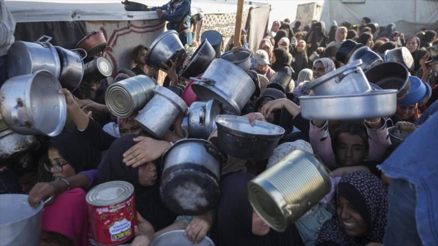 Los palestinos compiten en largas colas para conseguir algo de ayuda humanitaria en un centro de distribución respaldo en Jan Yunis, en el sur de la Franja de Gaza, 6 de diciembre de 2024. (Foto: AP)