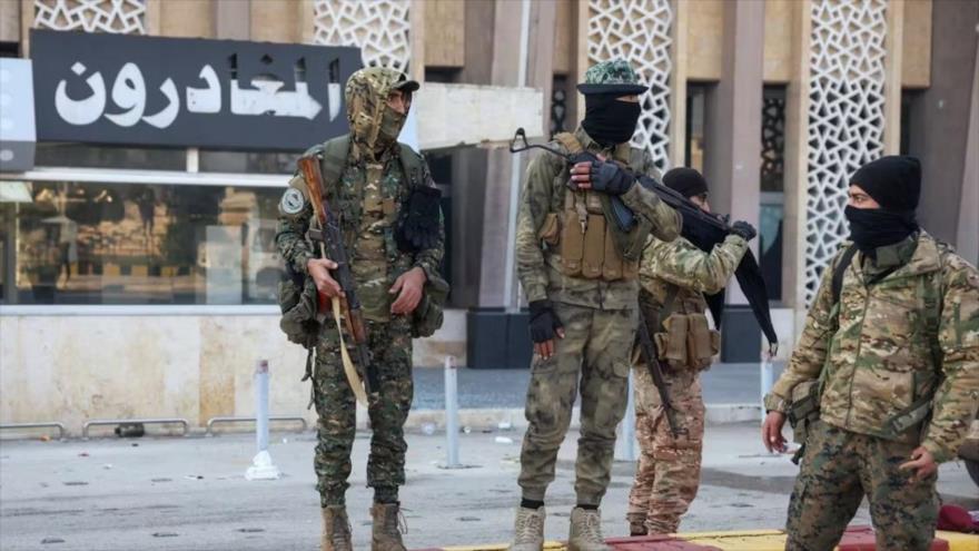 Combatientes afiliados a HTS estacionados en el aeropuerto de Alepo, Siria, 2 de diciembre de 2024. (Foto: AFP)