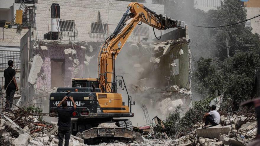 Una grúa de las fuerzas israelíes derriba casas pertenecientes a la familia palestina, Al-Quds, Palestina, 6 de junio de 2023.