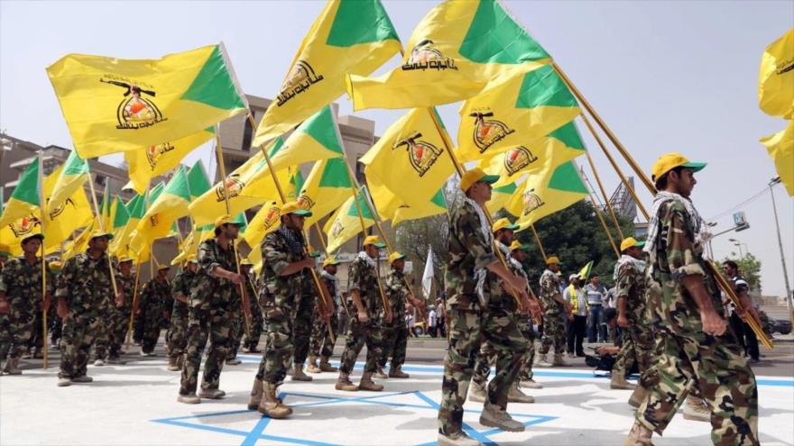 Miembros del grupo de Resistencia iraquí Kataeb Hezbolá marchan con uniformes militares y pisan una bandera israelí en Bagdad (Irak), 25 de julio de 2014. (Foto: AP)