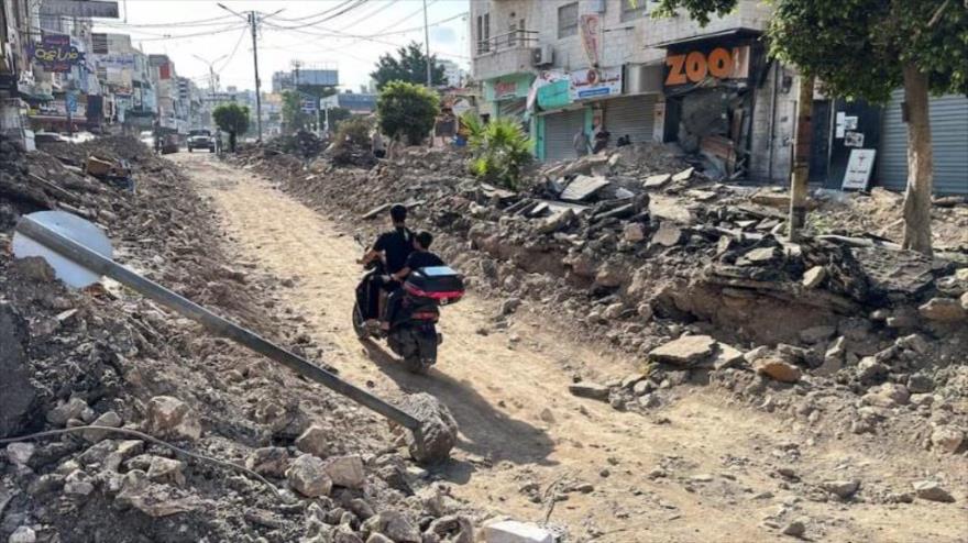 Palestinos viajan en motocicleta por una calle dañada tras una operación militar israelí en Yenín, en Cisjordania, 6 de septiembre de 2024. (Foto: REUTERS)