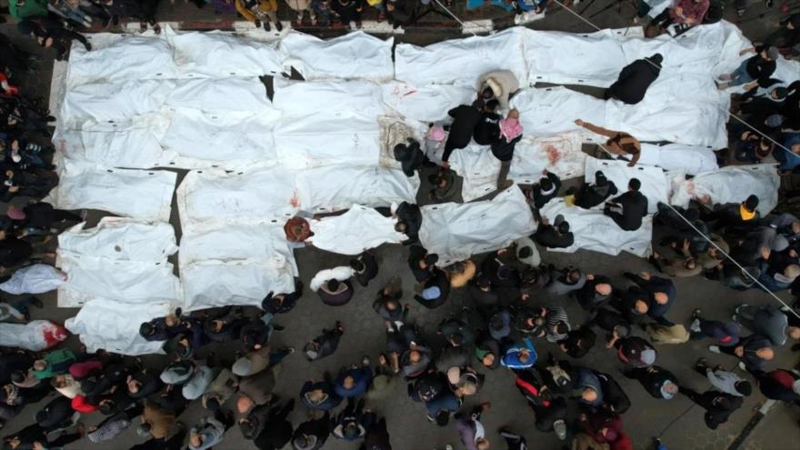 Una vista aérea muestra a palestinos de luto por sus familiares asesinados en un ataque israelí al centro de Gaza, 25 de diciembre de 2023. (Foto: AFP)