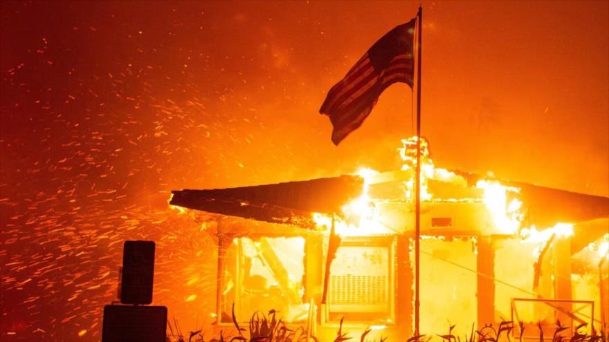 Una bandera estadounidense ondea mientras un incendio devora la estructura de un edificio en el lado oeste de Los Ángeles, 7 de enero de 2025. (Foto: Reuters)