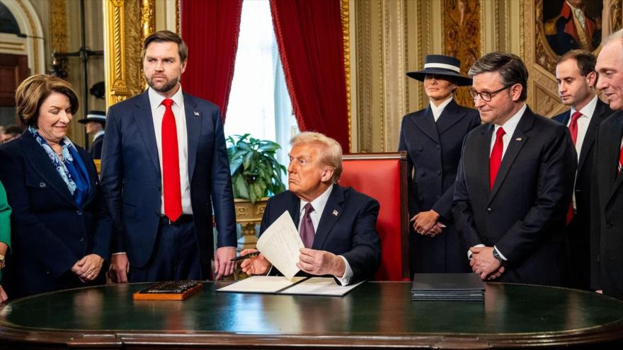 El presidente de EE.UU., Donald Trump, firma órdenes ejecutivas en el Despacho Oval, horas después de su investidura, 20 de enero de 2025.