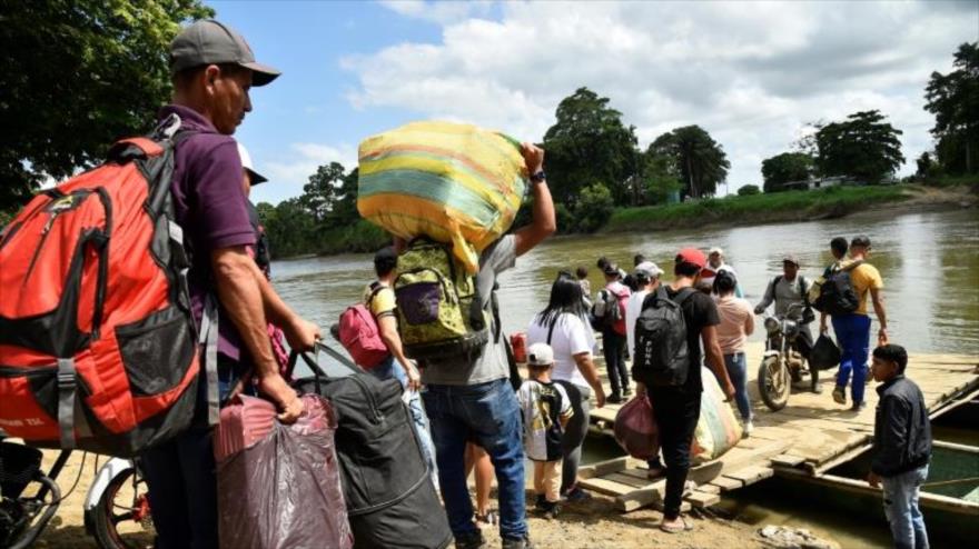 Colombianos desplazados por los recientes enfrentamientos entre grupos armados cruzan el río Tarra, en Tibú, Colombia, 19 de enero de 2025.