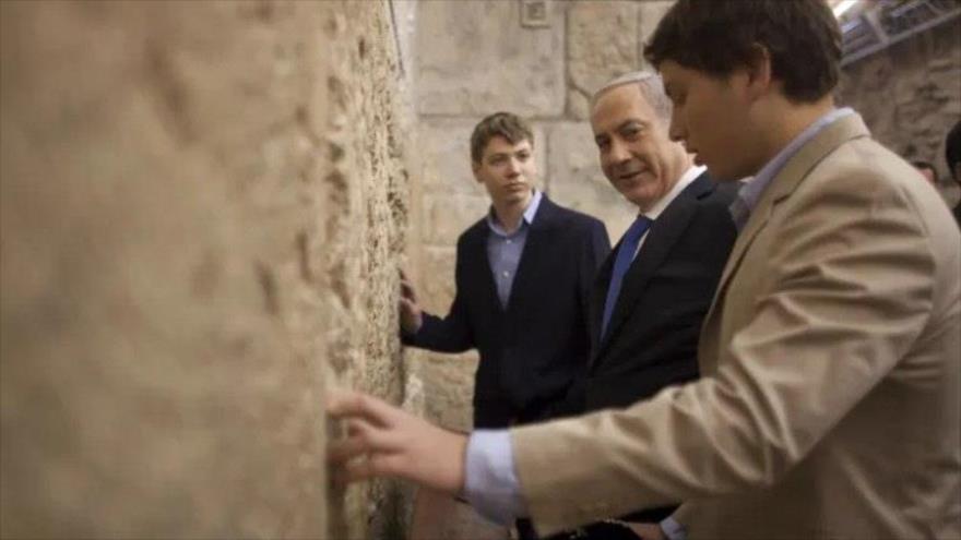 El primer ministro israelí, Benjamín Netanyahu, en el centro, con sus hijos Yair, al fondo, y Avner, a la derecha, en el muro de las lamentaciones. (Foto: AP)