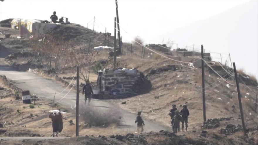 Un hombre sirio (izqda.) sujeta una bandera blanca al acercarse a soldados israelíes, en Maariyah, Siria, 19 de diciembre del 2024. (AP)