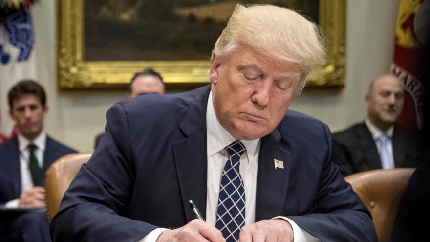 El presidente de EE.UU., Donald Trump firmando una orden para el equipo ejecutivo de la Casa Blanca. (Foto: AP) 