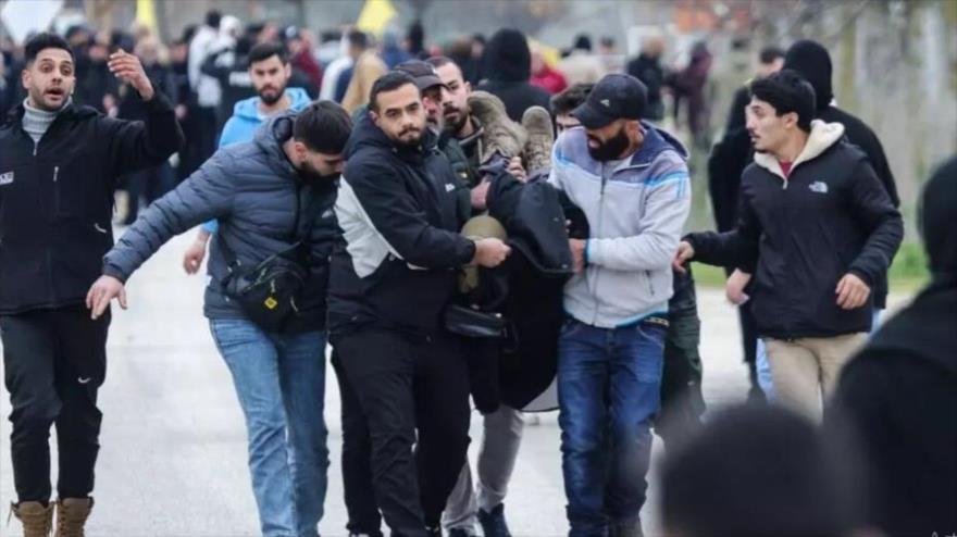 Los residentes llevan a un hombre herido por el fuego israelí a un lugar seguro en las afueras de Kfar Kila, en el sur del Líbano, 26 de enero de 2025. (Foto: AFP)