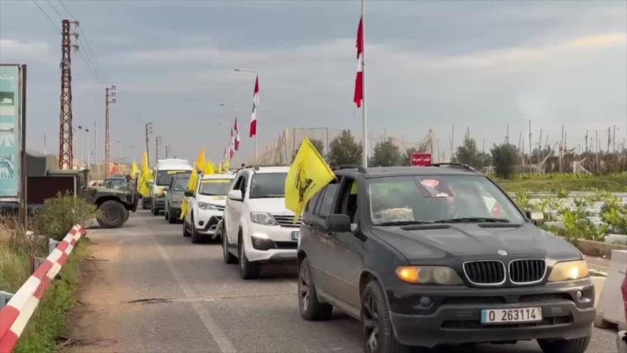 Los libaneses ondean la bandera de Hezbolá en regreso a sus hogares en sur del Líbano, 26 de enero de 2025. 