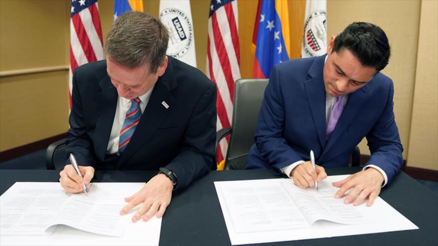 Mark Green, exdirector de la USAID, (izq.) y el opositor venezolano Carlos Vecchio, firmando un acuerdo de cooperación, octubre de 2019.