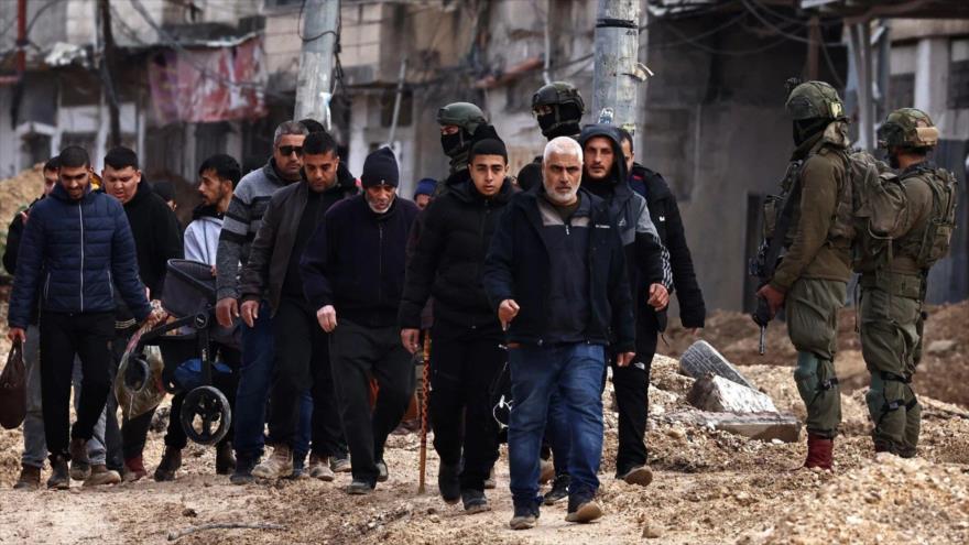 Soldados israelíes vigilan a los palestinos obligados a abandonar sus hogares, campo de refugiados de Nur Shams, Tulkarem, Cisjordania ocupada, 10 de febrero de 2025. (Foto: AFP)