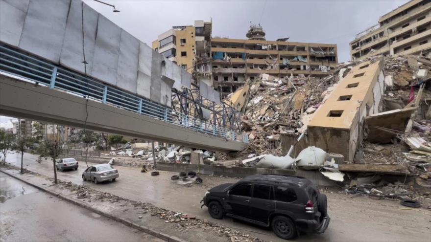 Autos pasan bajo un puente peatonal derruido y junto a un edificio destruido alcanzados por un ataque aéreo israelí en Dahiyeh, en un suburbio sureño de Beirut, El libano, 19 de noviembre de2024.
