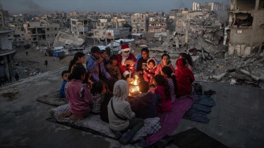 Los niños palestinos están acurrucados alrededor de un pequeño fuego por el frío.