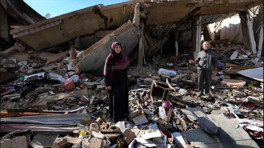 Una familia libanes sobre los escombros de su casa después de regresar a la aldea de Hanaouay, sur del Líbano, 28 de noviembre de 2024. (Foto: AP)