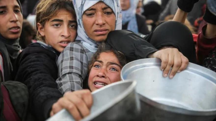 Palestinos claman por comida antes de que entrara en vigor el alto el fuego en Jan Yunis, Gaza. (foto: Reuters)