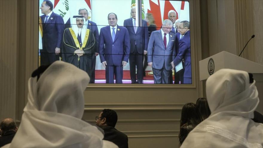 Los periodistas observan una pantalla que muestra al presidente egipcio, Abdel Fatah al-Sisi, en el centro, con líderes árabes, en el salón de prensa de la cumbre de la Liga Árabe, en el Cairo, 4 de marzo de 2025. (Foto: AP)