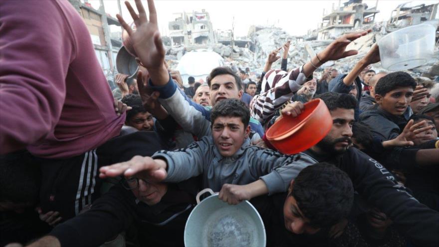 Palestinos hacen cola para recibir una comida caliente proporcionada por un grupo de ayuda en el campo de refugiados de Yabalia, 4 de marzo de 2025.