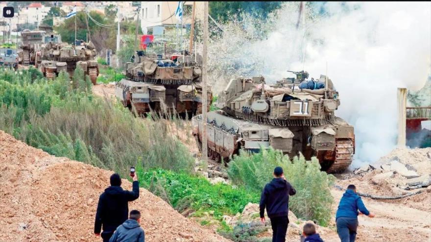 Jóvenes palestinos lanzan piedras contra tanques israelíes que entran en campamento de refugiados palestinos de Yenín, Cisjordania ocupada. (Foto: AFP)
