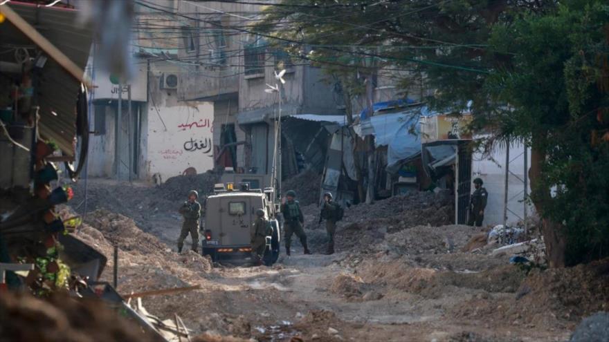 Soldados israelíes se encuentran en una carretera arrasada mientras realizan una redada violenta en Tulkarem, Cisjordania, 28 de enero de 2025. (Foto: AFP)