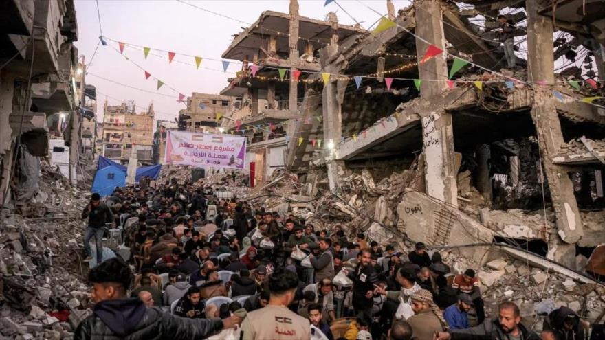 La gente se reúne en espera de comida para romper el ayuno en el primer día del mes sagrado de ayuno musulmán del Ramadán en Yabalia, Gaza, 1 de marzo de 2025.