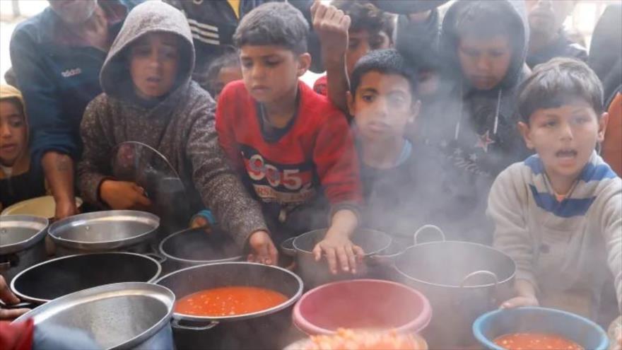 Niños palestinos esperan recibir comida de una cocina benéfica en Jan Yunis, Gaza, el 9 de marzo de 2025 (foto: Reuters)