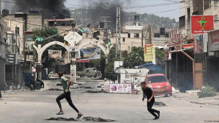 Jóvenes palestinos corren en las calles de Yenín durante ataques del ejército israelí. (foto: AFP)