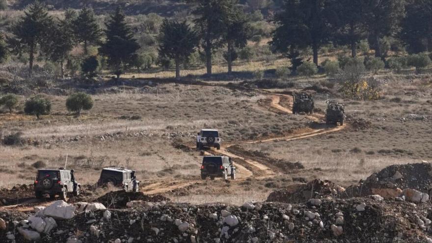 Vehículos israelíes cruzan la valla de seguridad la que separa los Altos del Golán anexados por Israel de Siria, en la ciudad de Majdal Shams, 9 de diciembre de 2024.