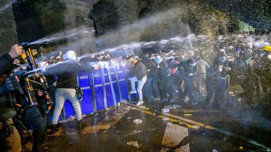 Manifestantes reaccionan a los gases lacrimógenos al enfrentarse a la policía durante una protesta antigubernamental en Estambul, el 21 de marzo de 2025. (Foto: AFP)