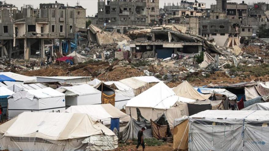 Un campamento para refugiados palestinos en el centro de la Franja de Gaza cerca de edificios derrumbados en ataques israelíes.