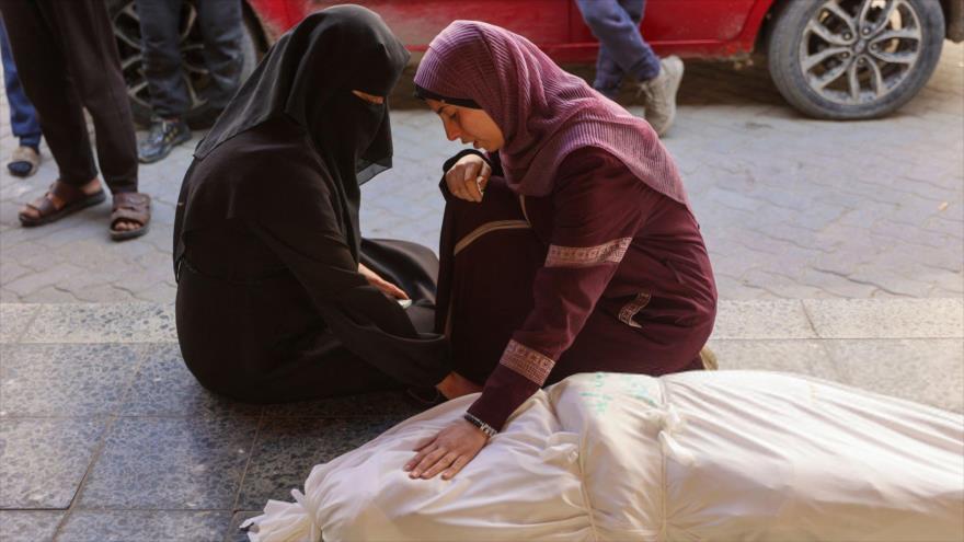 Mujeres palestinas lloran sobre el cuerpo de su familiar, quien murió en un bombardeo israelí, en la Ciudad de Gaza, 26 de marzo de 2025. (Foto: AFP)