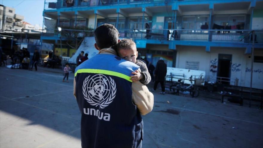 Un miembro de la UNRWA consuela a un niño en una escuela convertida en refugio en Nuseirat, Gaza, 2024. (Foto: UNRWA)