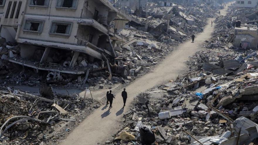 Palestinos caminan junto a casas destruidas en el norte de la Franja de Gaza. (Foto:Reuters)