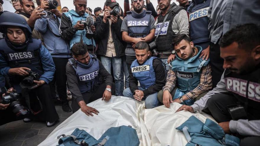 Familiares y colegas de los periodistas palestinos asesinados en un ataque de Israel en la Franja de Gaza, lloran durante su ceremonia fúnebre en Deir al-Balah, Gaza.