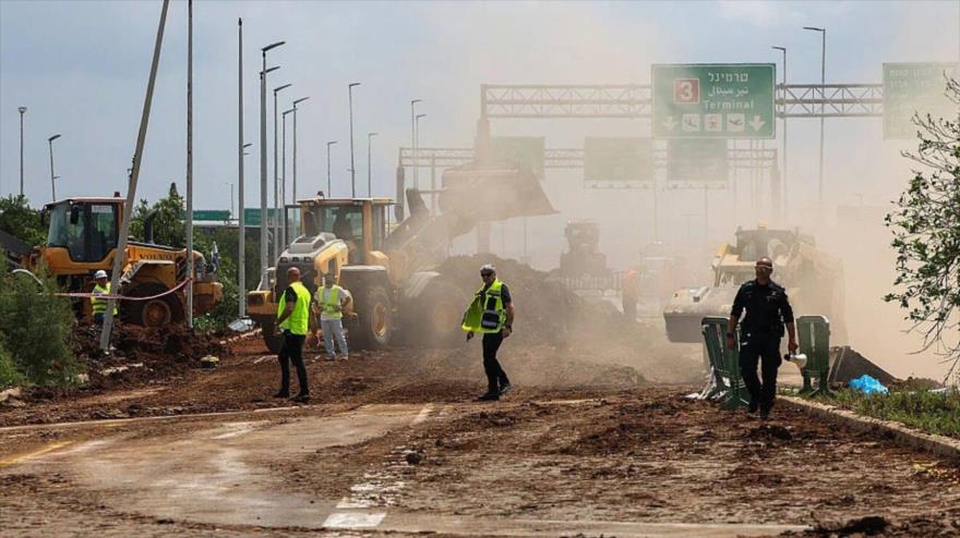 Servicios de emergencia despejan una carretera fuera del aeropuerto Ben Gurión después de que un misil yemení impactara cerca del sitio, 4 de mayo de 2025.