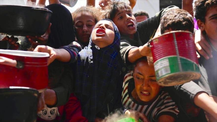 Palestinos luchan por conseguir alimentos donados en una cocina comunitaria en Franja de Gaza, 5 de mayo de 2025. (Foto: AP)